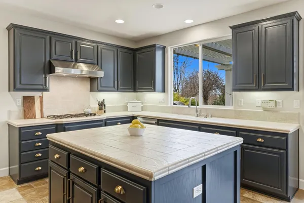 a kitchen with stainless steel appliances a sink a stove a refrigerator and cabinets