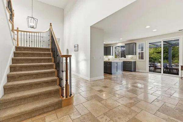 a view of staircase with lots of frames on wall and wooden floor