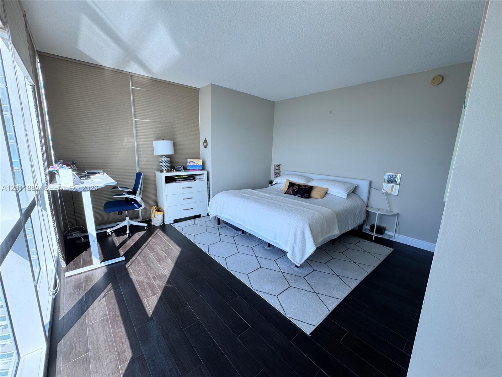 2101 Brickell Avenue, Unit 3205 Miami, FL 33129 - Photo 12 of 31 a bedroom with a bed and wooden floor