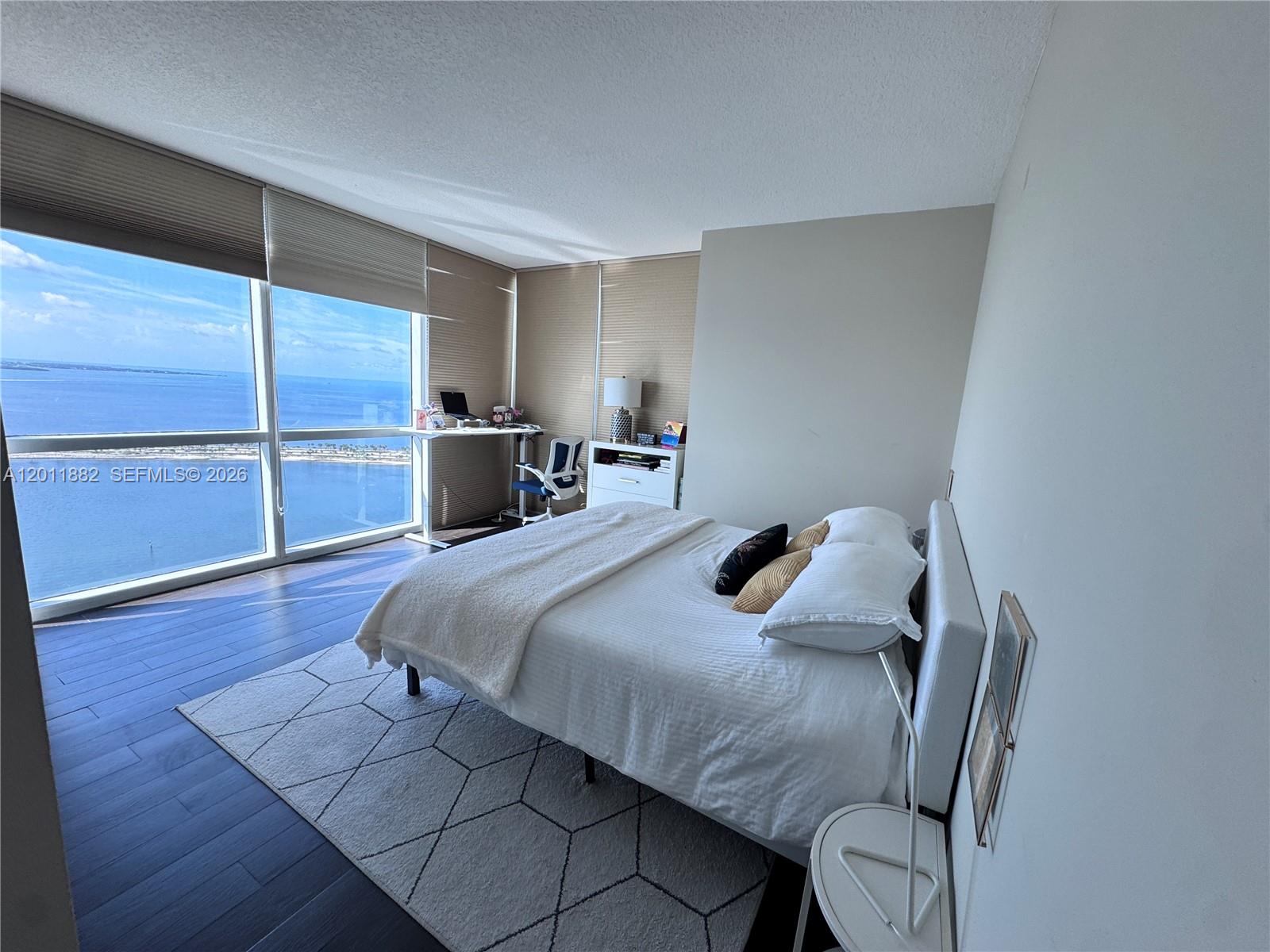 2101 Brickell Avenue, Unit 3205 Miami, FL 33129 - Photo 13 of 31 a bedroom with a bed and wooden floor