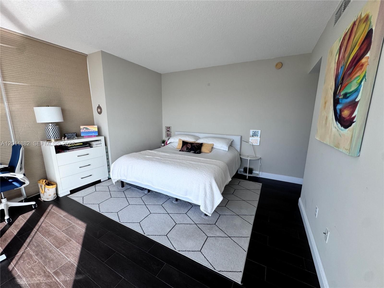 2101 Brickell Avenue, Unit 3205 Miami, FL 33129 - Photo 14 of 31 a bedroom with a bed and a lamp on dresser