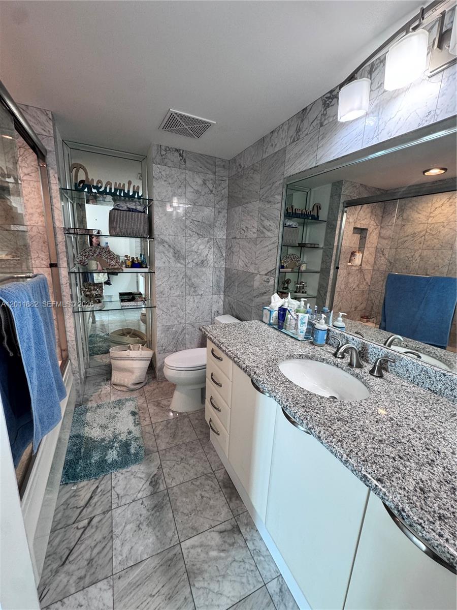 2101 Brickell Avenue, Unit 3205 Miami, FL 33129 - Photo 15 of 31 a bathroom with a granite countertop sink toilet and shower