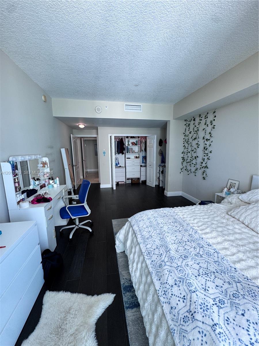 2101 Brickell Avenue, Unit 3205 Miami, FL 33129 - Photo 24 of 31 a bedroom with a bed and wooden floor