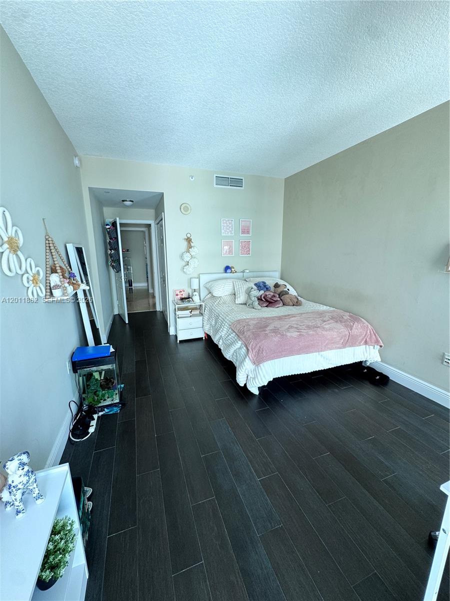2101 Brickell Avenue, Unit 3205 Miami, FL 33129 - Photo 26 of 31 a bedroom with a bed and wooden floor