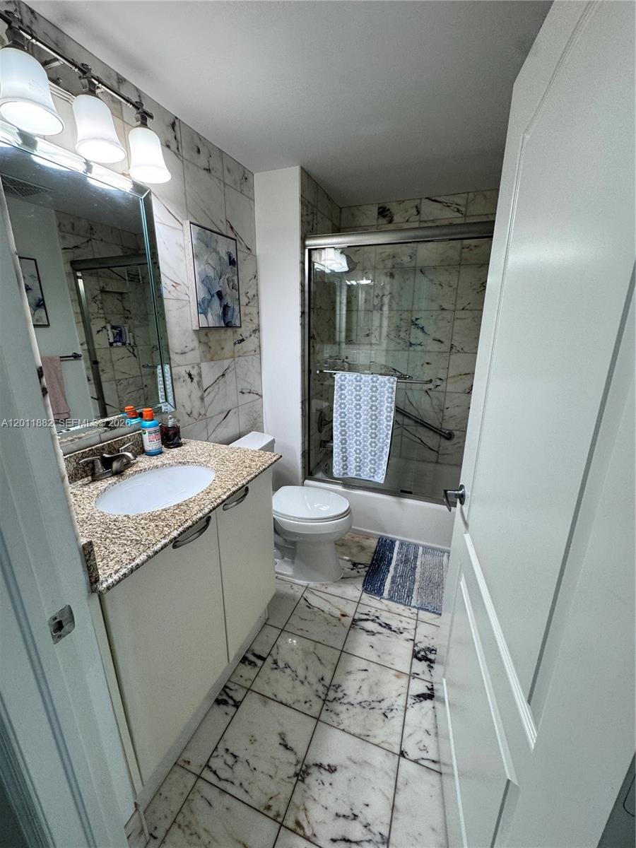 2101 Brickell Avenue, Unit 3205 Miami, FL 33129 - Photo 27 of 31 a bathroom with a granite countertop sink toilet and shower