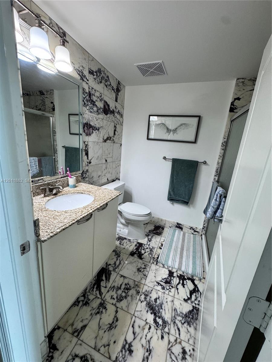 2101 Brickell Avenue, Unit 3205 Miami, FL 33129 - Photo 29 of 31 a bathroom with a sink toilet and shower