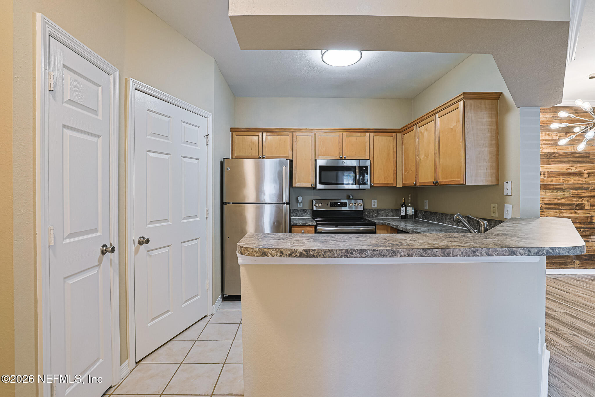 10961 Burnt Mill Road, Unit 426 Jacksonville, FL 32256 - Photo 2 of 24 a kitchen with granite countertop a refrigerator a stove a sink a center island and cabinets