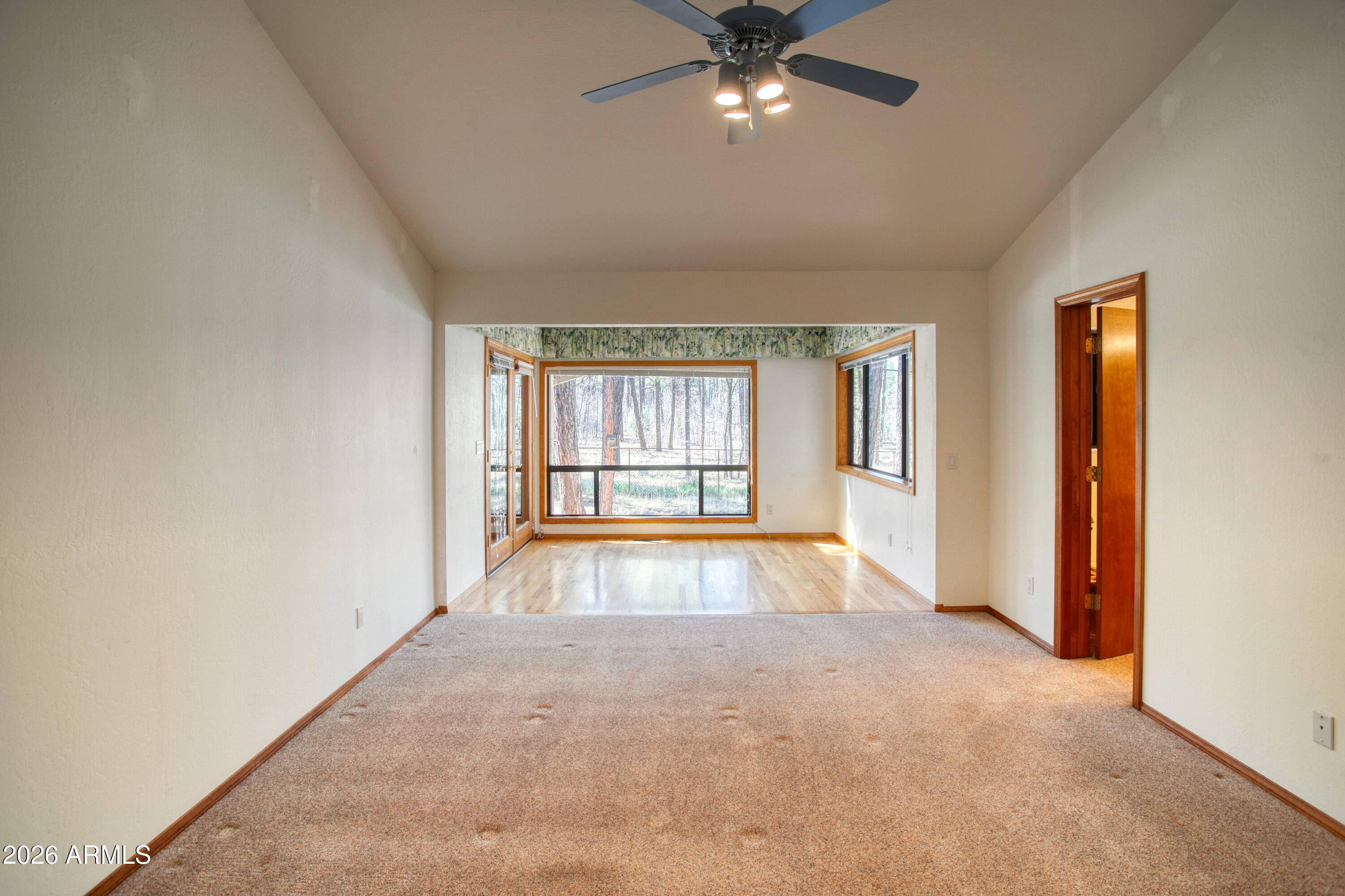 71 East Turkey Track Lane Pinetop, AZ 85935 - Photo 10 of 50 an empty room with chandelier fan and windows