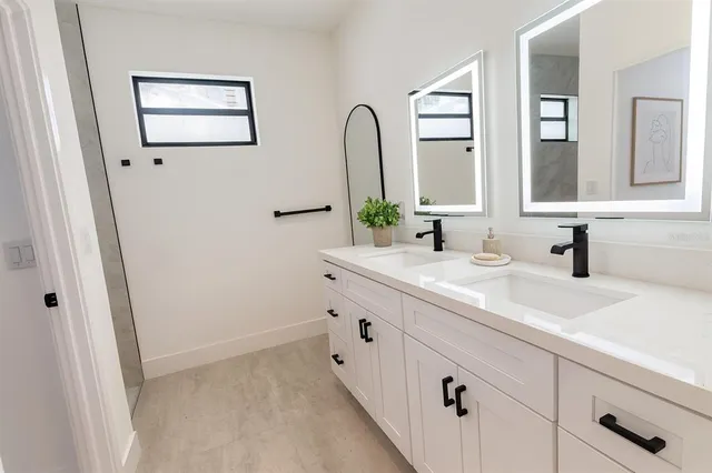 a bathroom with a double vanity sink and a mirror