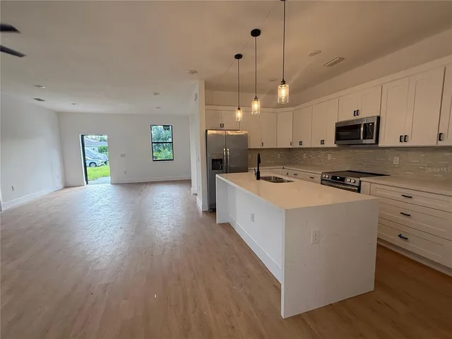 a kitchen with stainless steel appliances granite countertop a stove a sink and a microwave