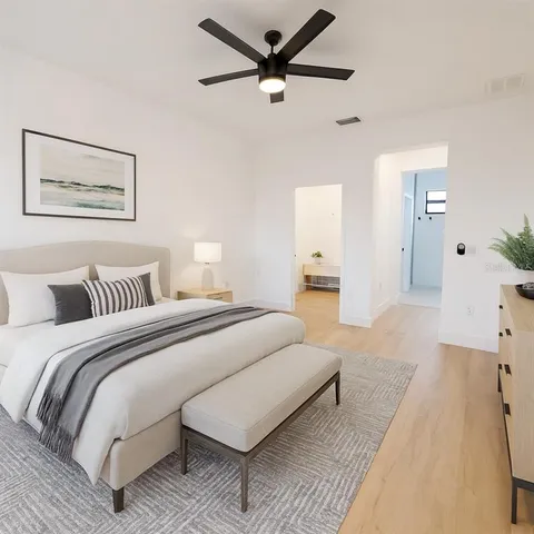 a spacious bedroom with a bed and a chandelier