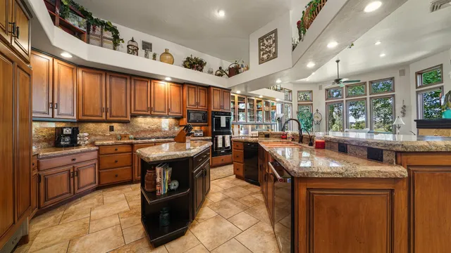 a living room with furniture kitchen view and a large window