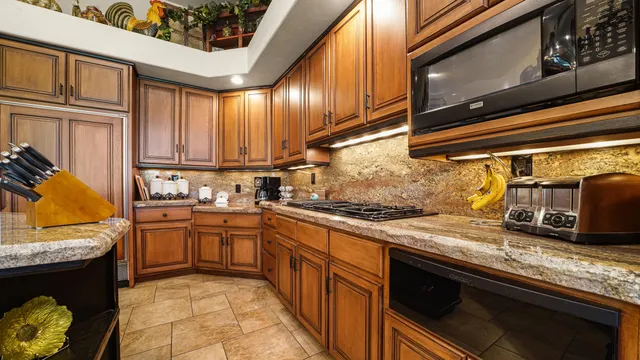 a spacious bathroom with a granite countertop sink a mirror and a bathtub