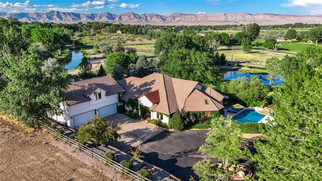 a view of a white house with a big yard and a large tree