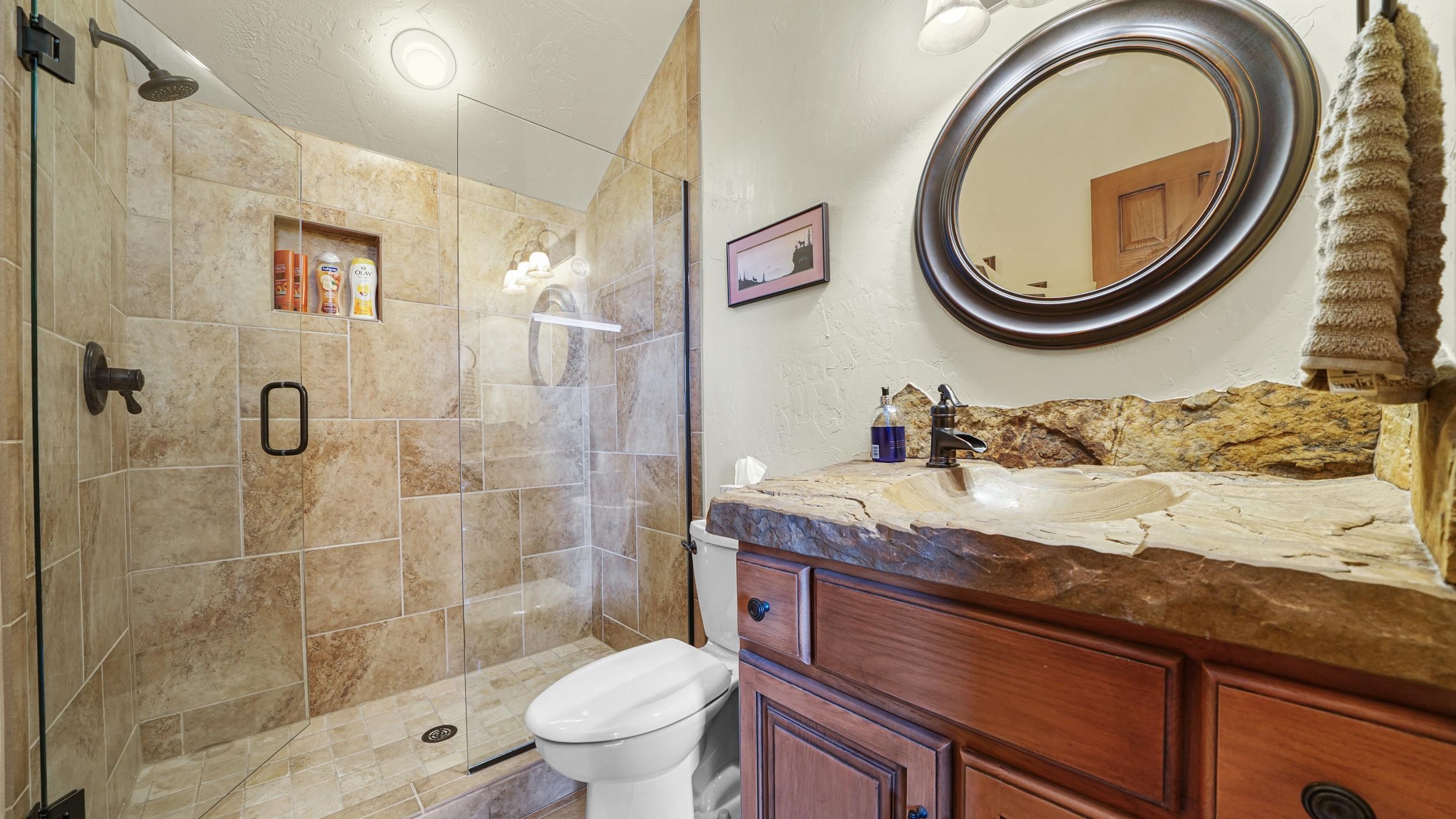 815 25 Road Grand Junction, CO 81505 - Photo 33 of 42 a bathroom with a granite countertop toilet a sink and a mirror