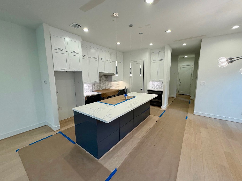 2630 Peckham Street Houston, TX 77098 - Photo 7 of 50 a large white kitchen with a sink a refrigerator and white cabinets