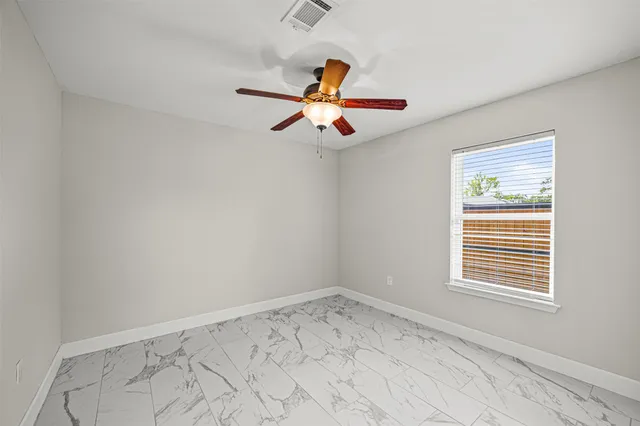 a view of empty room with ceiling fan