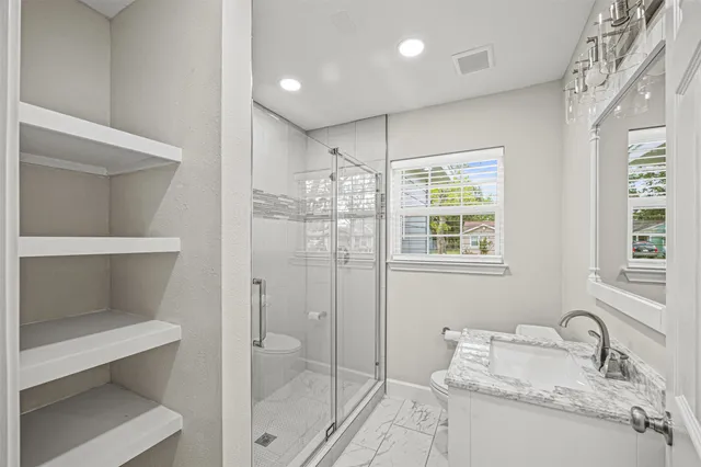 a bathroom with a granite countertop sink toilet and shower
