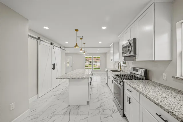 a kitchen with stainless steel appliances granite countertop a sink stove and cabinets