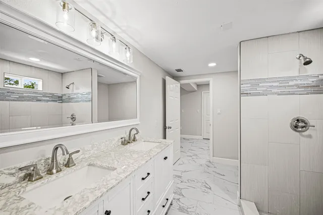 a bathroom with a granite countertop sink vanity and mirror