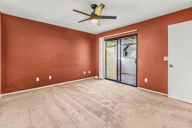 a view of an empty room with a ceiling fan