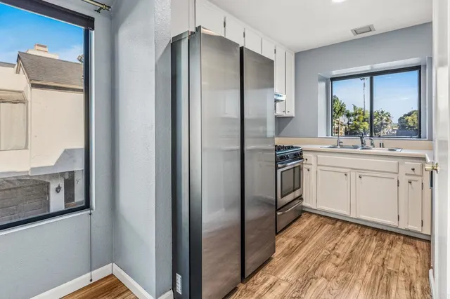 a kitchen with stainless steel appliances a refrigerator sink and cabinets