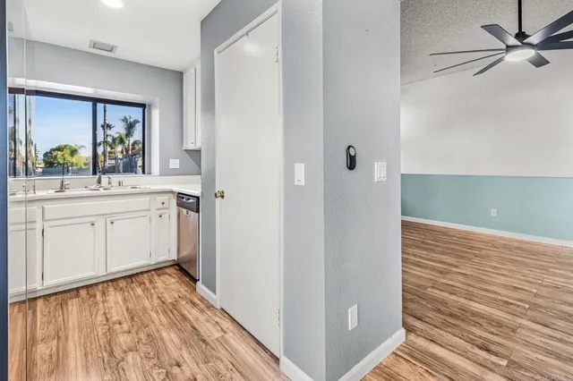 a view of a hallway with wooden floor and a bathroom