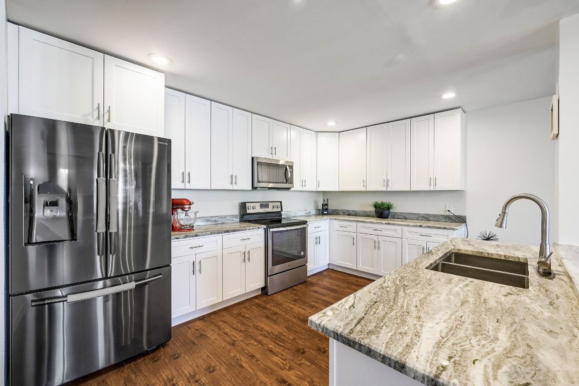 409 Seawind Lakeway, TX 78734 - Photo 8 of 18 a kitchen with granite countertop a refrigerator stove top oven and sink