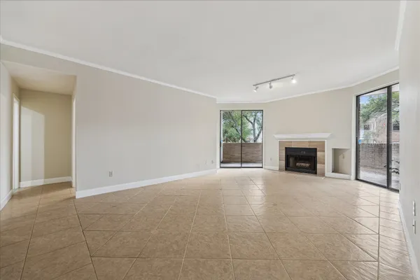 an empty room with floor to ceiling window and fireplace