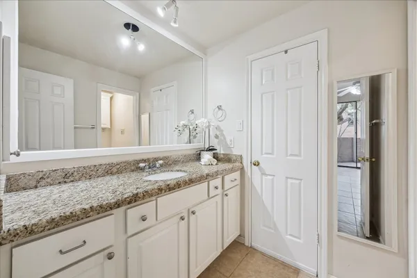 a bathroom with a granite countertop sink and a mirror