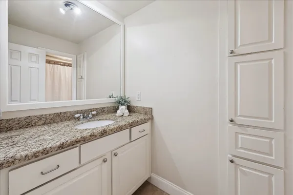 a bathroom with a granite countertop sink and a mirror