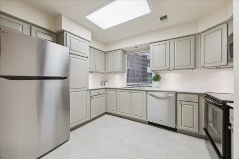a kitchen with a refrigerator sink and cabinets