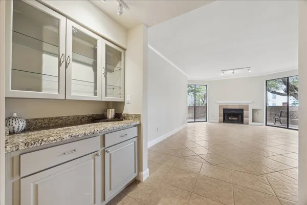 a kitchen with granite countertop a stove a sink and a white cabinets