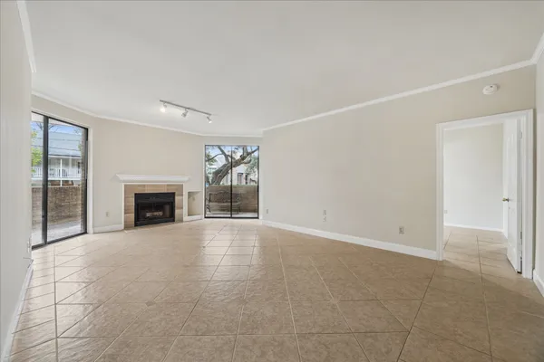 an empty room with floor to ceiling window and fireplace