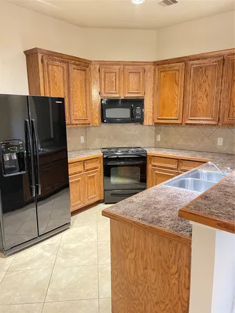 a kitchen with stainless steel appliances granite countertop a refrigerator stove top oven and sink
