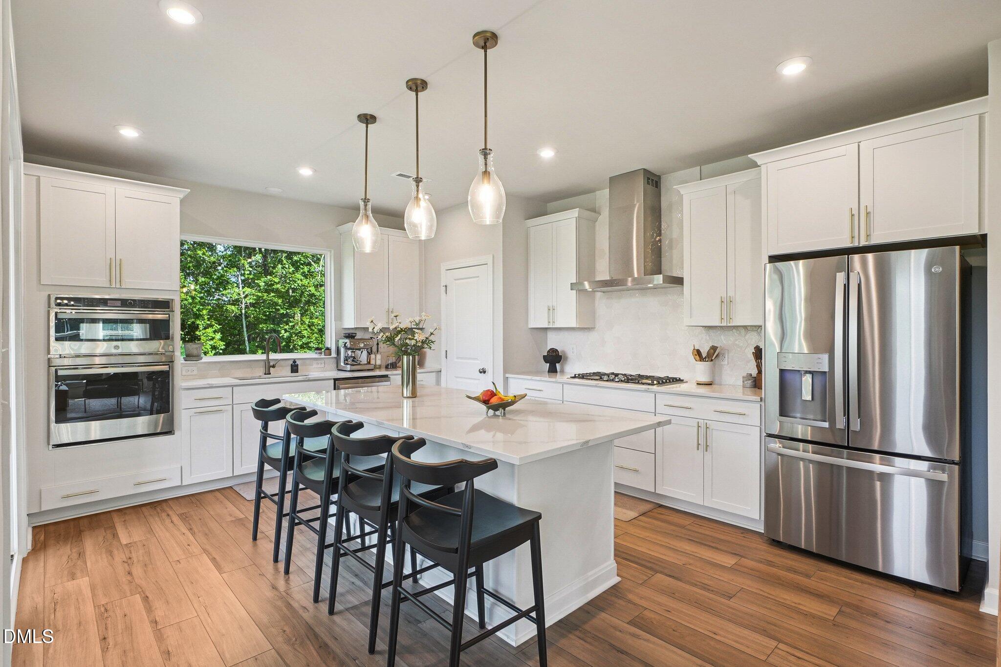 4822 Cypress Tree Lane Raleigh, NC 27612 - Photo 9 of 28 a kitchen with stainless steel appliances granite countertop a refrigerator a stove a sink a dining table and chairs with wooden floor