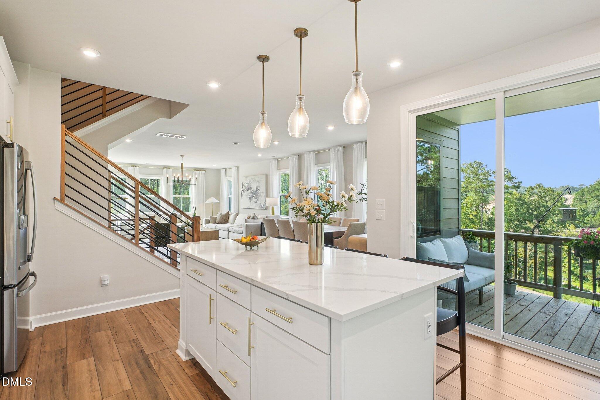 4822 Cypress Tree Lane Raleigh, NC 27612 - Photo 11 of 28 a kitchen with a sink a center island a dining table and chairs