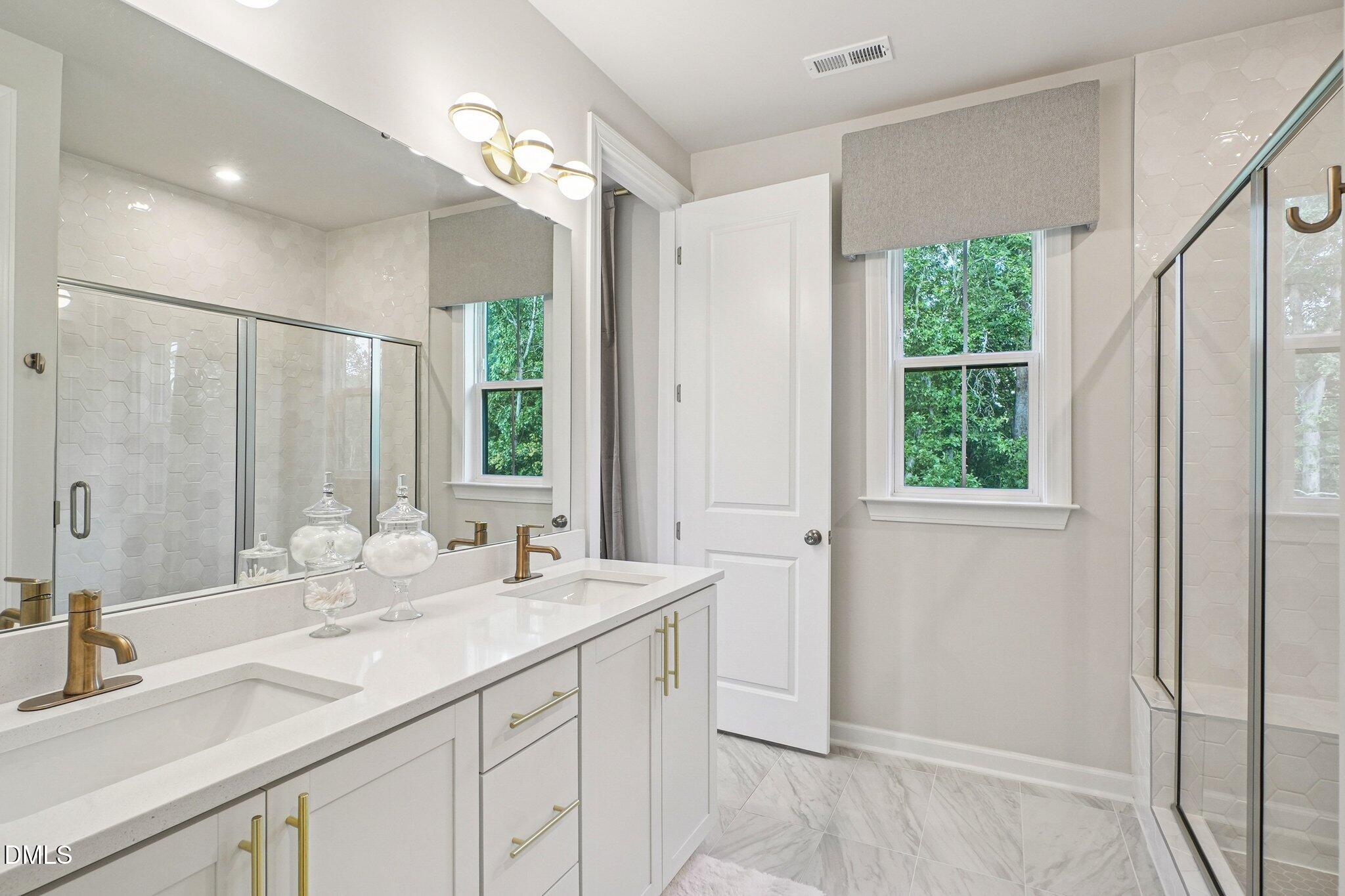 4822 Cypress Tree Lane Raleigh, NC 27612 - Photo 18 of 28 a bathroom with a double vanity sink and a mirror