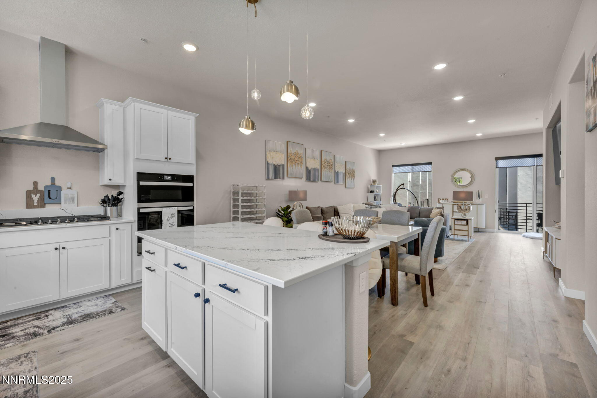 a large white kitchen with lots of counter space a sink appliances and dining table