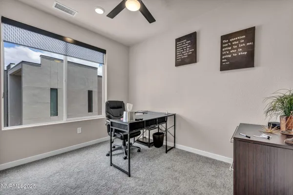 a view of a workspace with furniture and a window