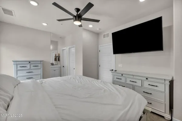 a bedroom with a large bed and a flat screen tv
