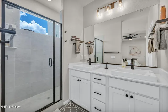 a bathroom with a granite countertop sink mirror and shower