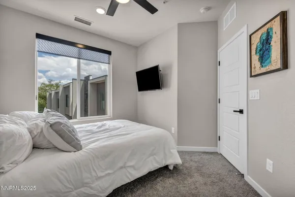 a bedroom with a large bed and a flat screen tv