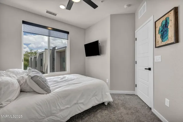 a bedroom with a large bed and a flat screen tv