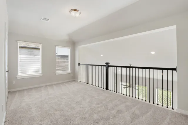 an empty room with windows and cabinet