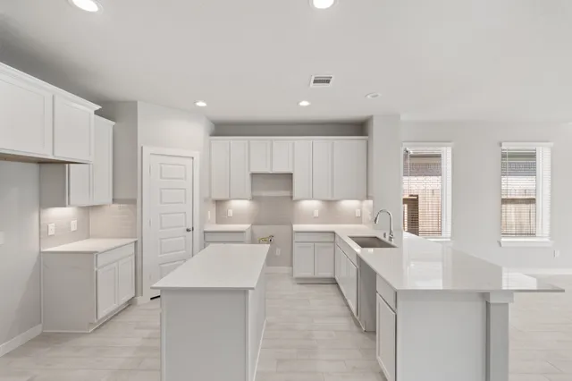 a large white kitchen with cabinets