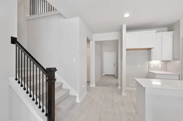 a view of a hallway with wooden floor and staircase