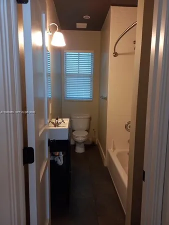 a bathroom with a sink and mirror with toilet