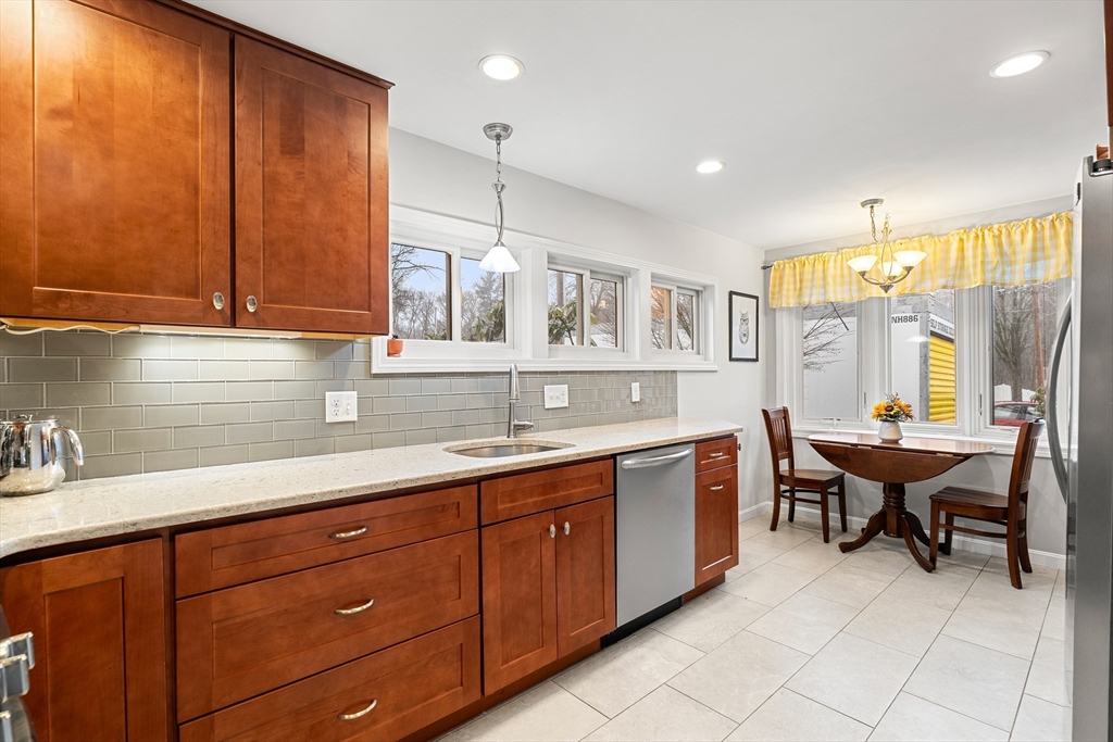51 Winslow Road Reading, MA 01867 - Photo 8 of 40 a kitchen with kitchen island granite countertop a sink window and cabinets