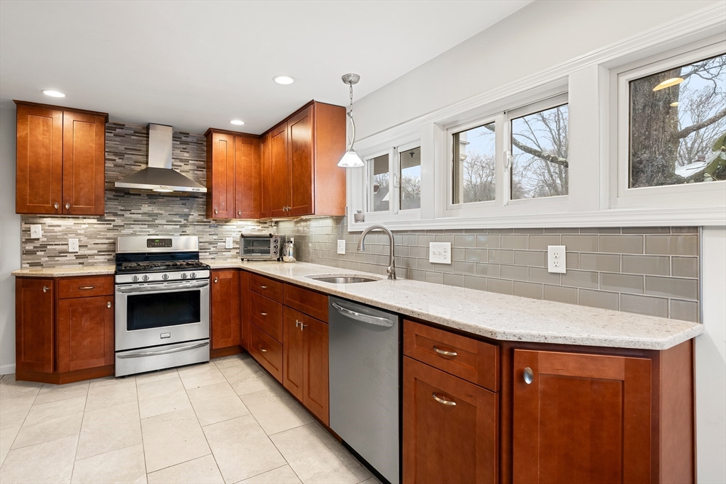 51 Winslow Road Reading, MA 01867 - Photo 9 of 40 a kitchen with stainless steel appliances granite countertop a sink stove and cabinets